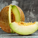 widok-z-przodu-pokrojony-swiezy-melon-na-biurku-w-ciemnym-swietle-slodkie-owoce-letnie